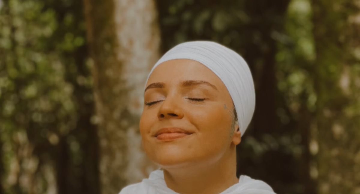 Prem Ras Kaur de olhos fechados ao sol, respirando com calma